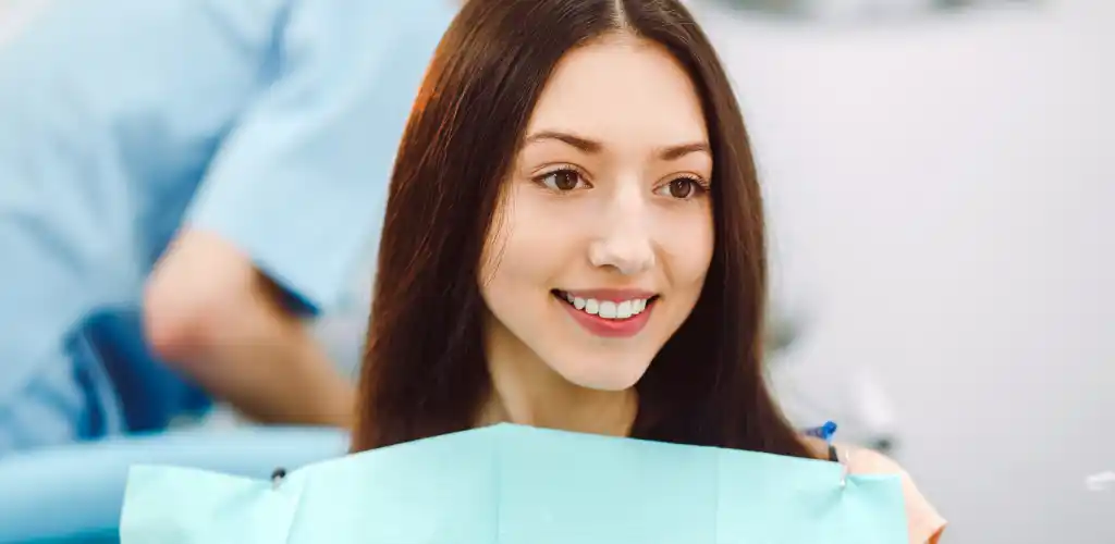 Is Teeth Whitening Safe? A Birmingham Dentist Explains What You Really Need to Know 2 patient smiling and checking teeth whitening results in a dental clinic mirror