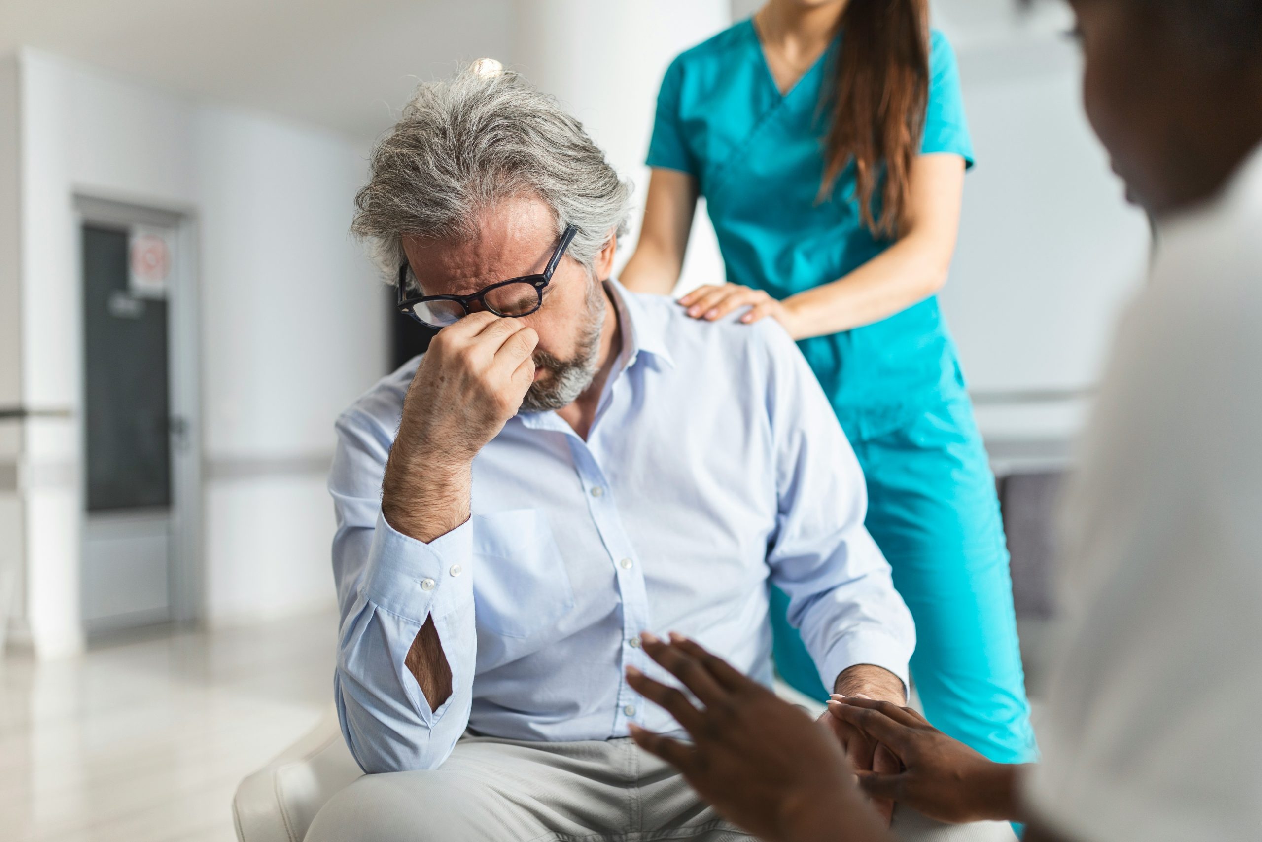 Managing Dental Anxiety in Modern Birmingham Clinics 2 Man appearing anxious while being reassured by healthcare professionals